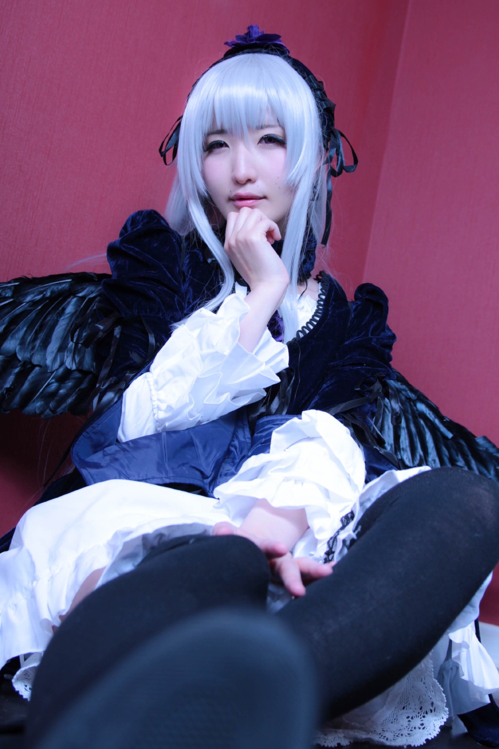 1girl black_legwear blurry dress frills gothic_lolita hairband long_sleeves realistic silver_hair sitting solo suigintou wings