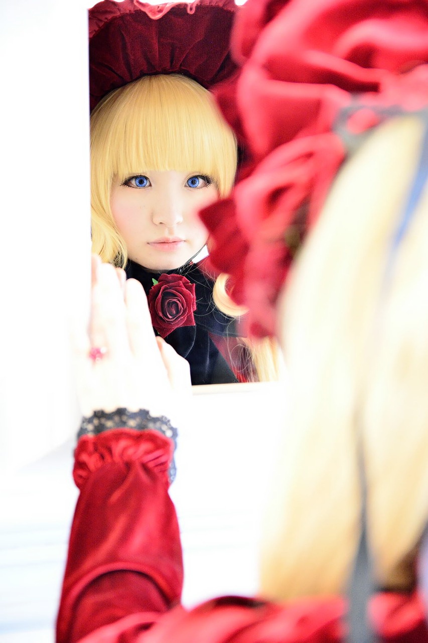 1girl blonde_hair blue_eyes blurry blurry_foreground depth_of_field dress flower lips motion_blur red_flower rose solo