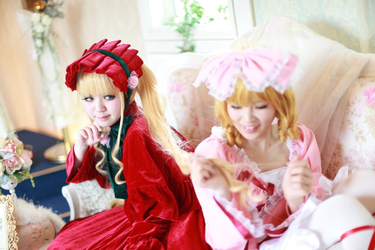 2girls blonde_hair blue_eyes blurry blurry_background blurry_foreground bonnet closed_eyes depth_of_field dress flower hat long_hair multiple_cosplay multiple_girls photo realistic shinku sitting tagme umbrella