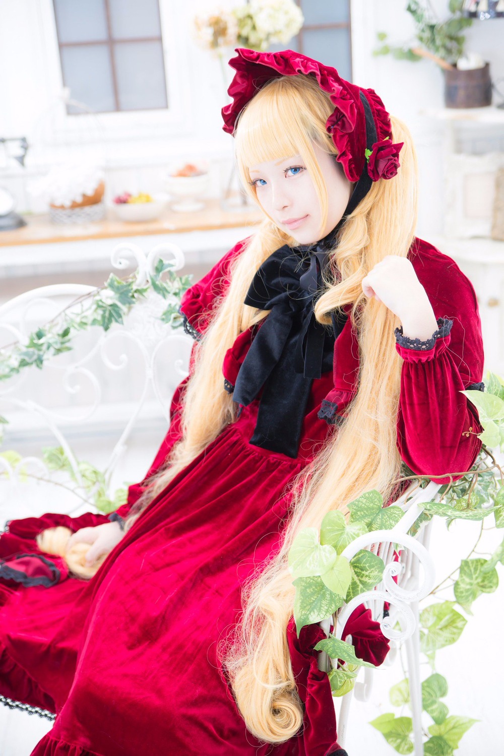 1girl blonde_hair blue_eyes blurry blurry_background blurry_foreground bonnet depth_of_field dress flower long_hair photo red_dress rose shinku solo