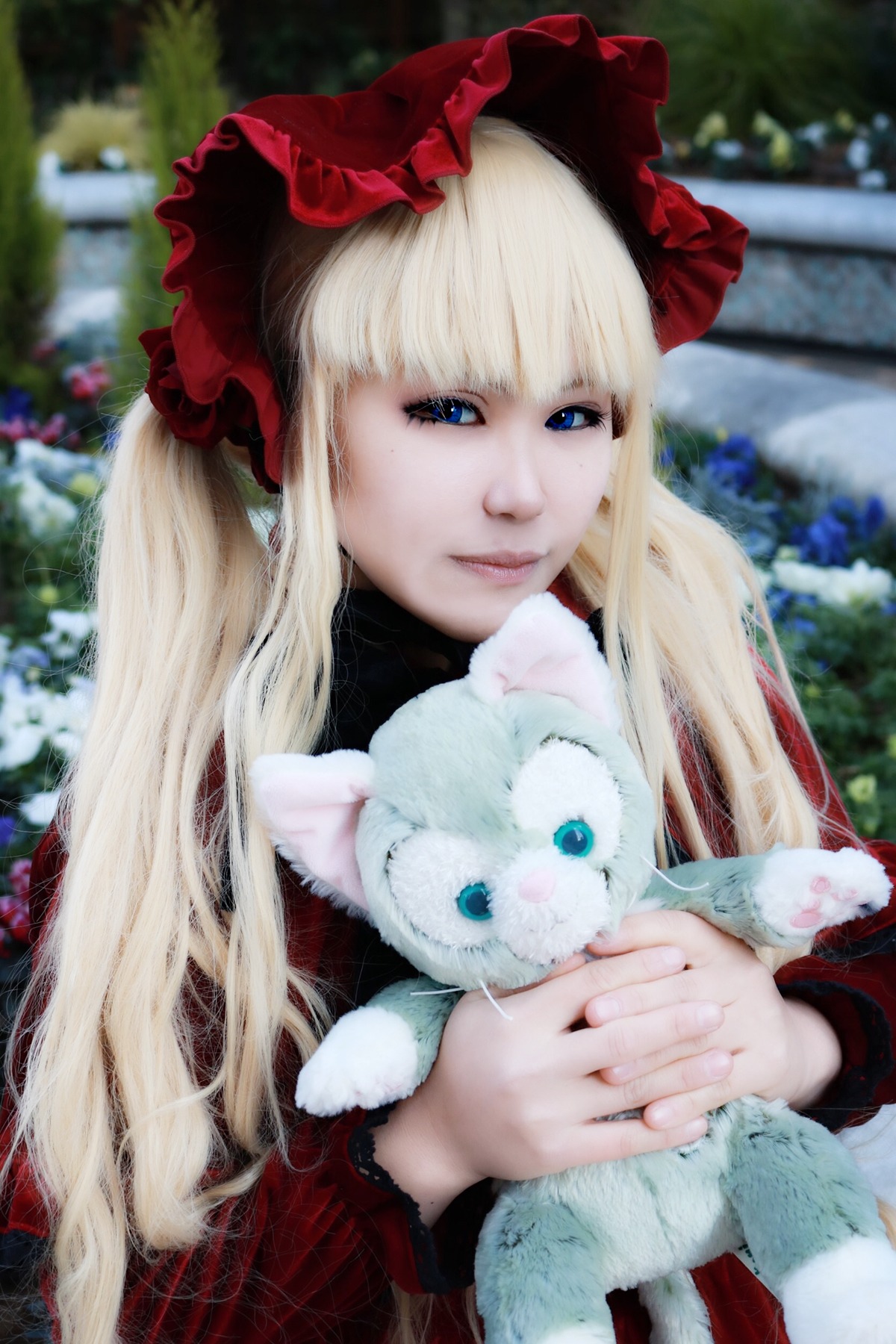 1girl animal bangs blonde_hair blue_eyes blurry blurry_background bonnet closed_mouth depth_of_field holding_animal long_hair long_sleeves outdoors red_dress shinku smile solo upper_body