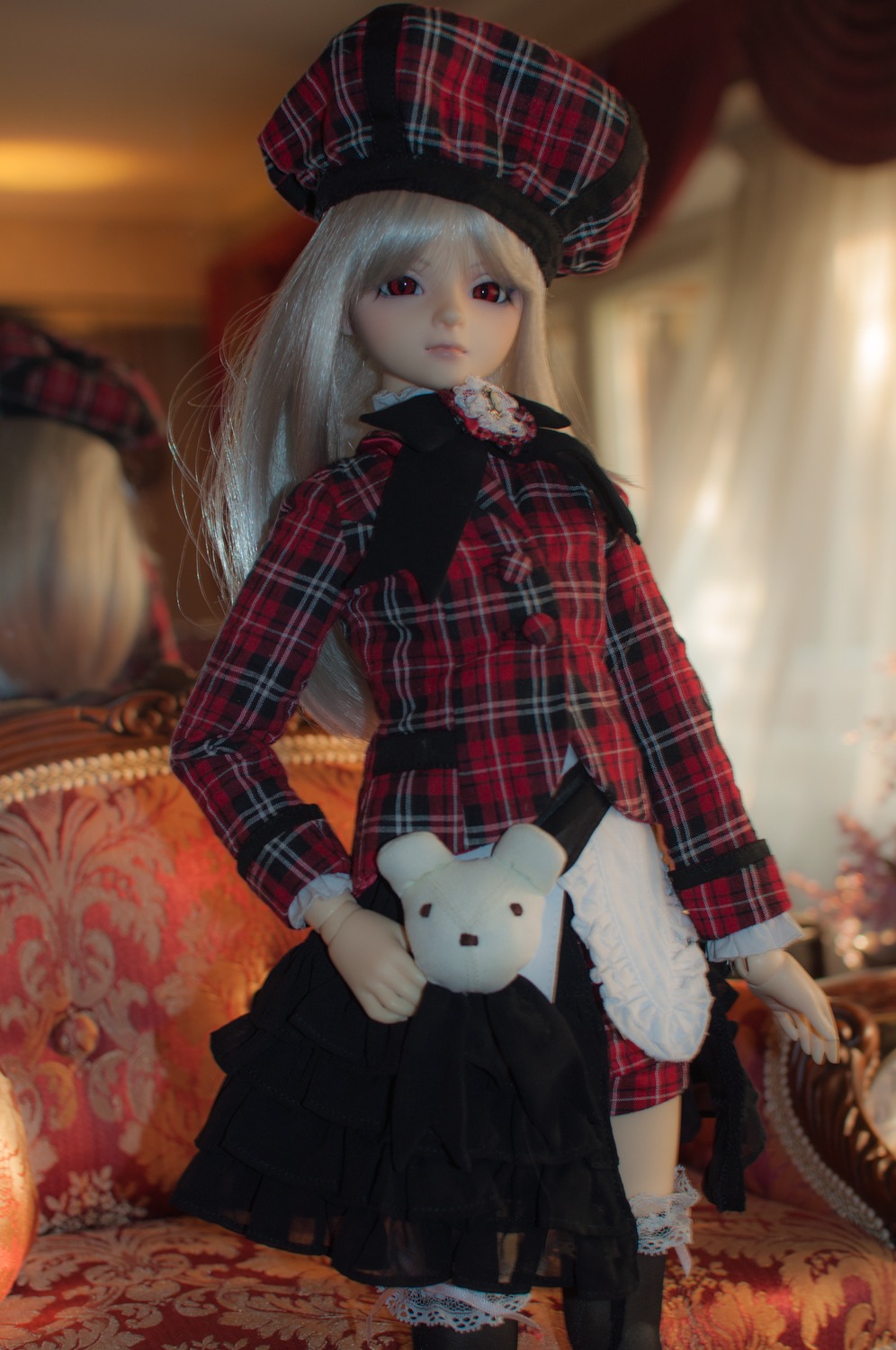 1girl blurry blurry_background depth_of_field doll hat long_hair long_sleeves looking_at_viewer plaid plaid_bow plaid_dress plaid_pants plaid_scarf plaid_shirt plaid_skirt red_eyes sitting solo stuffed_animal suigintou white_hair