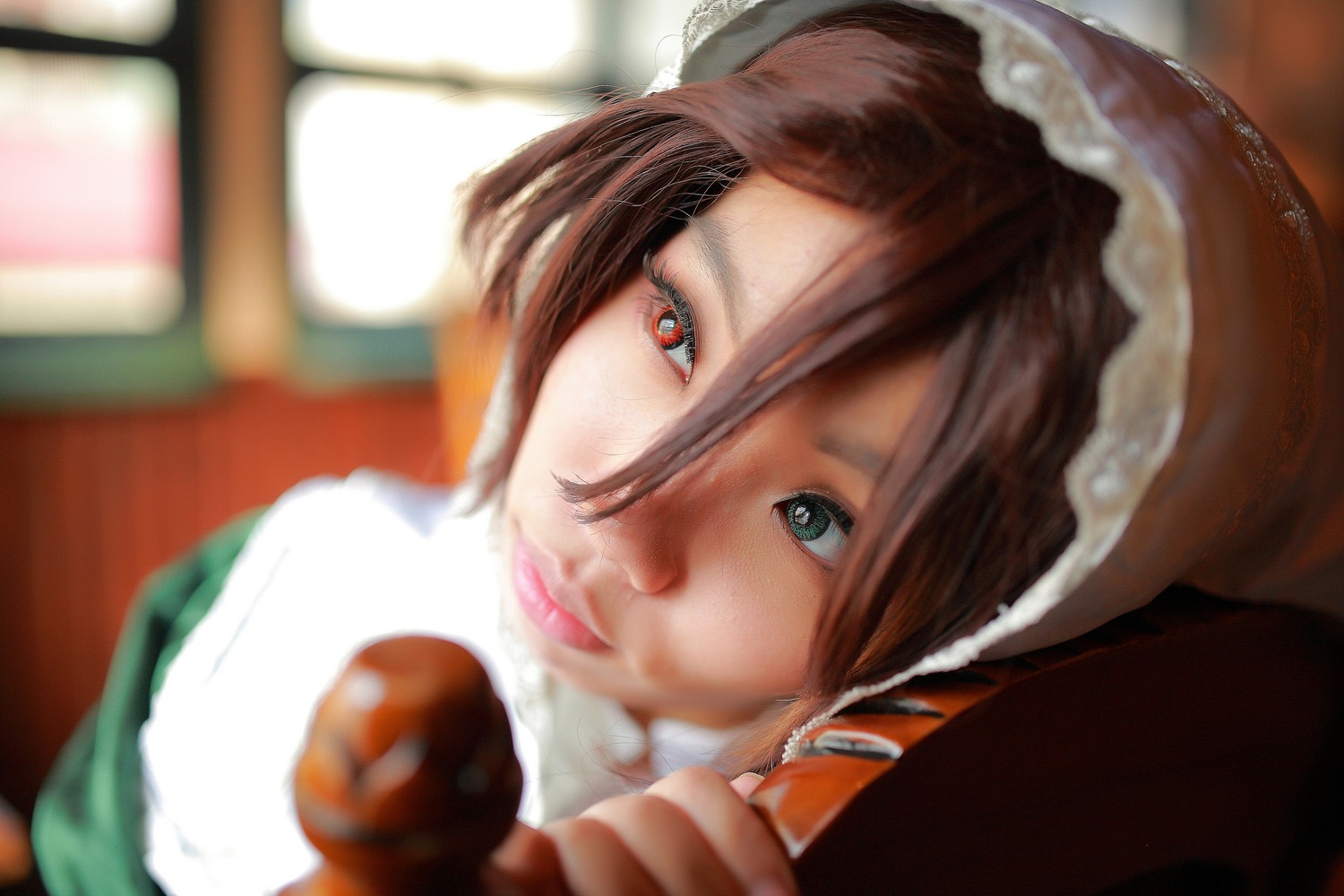 1girl auto_tagged blurry blurry_background blurry_foreground brown_hair depth_of_field food hat heterochromia indoors looking_at_viewer santa_hat solo suiseiseki