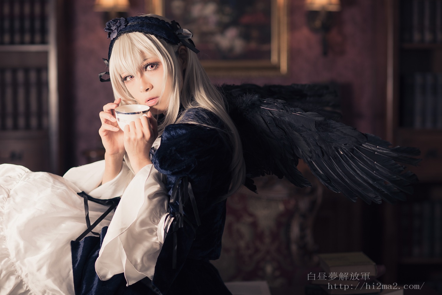 1girl angel_wings black_wings blonde_hair blurry blurry_background bookshelf depth_of_field dress feathered_wings hairband holding indoors long_hair long_sleeves looking_at_viewer solo suigintou wings
