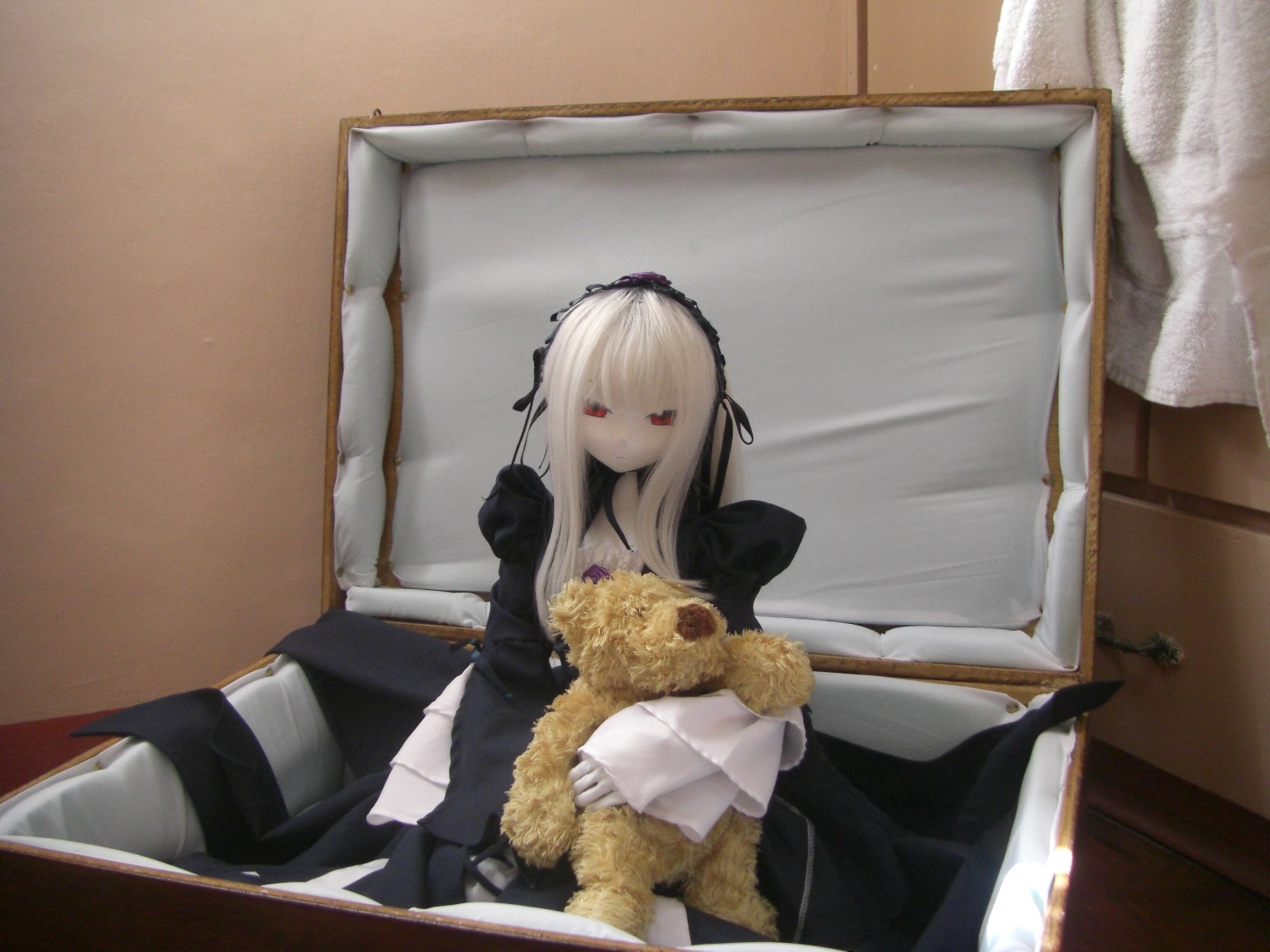 1girl black_dress bouquet doll dress flower frills hairband long_hair long_sleeves red_eyes rose sitting solo suigintou