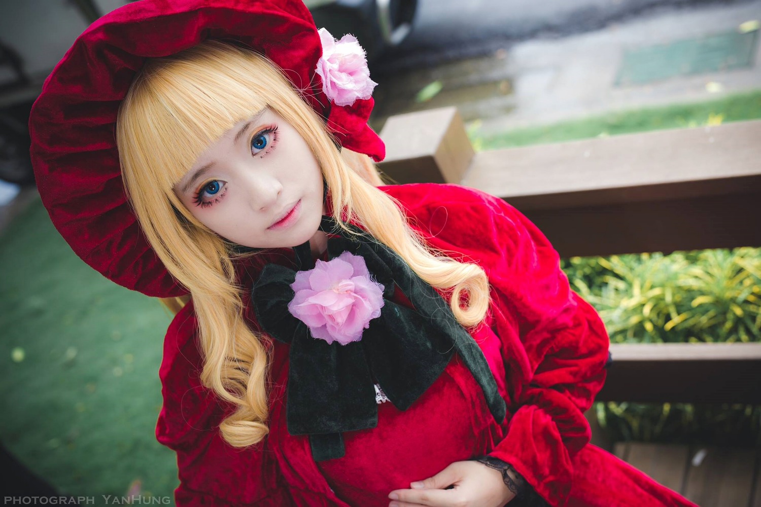 1girl bangs blonde_hair blue_eyes blurry blurry_background bonnet depth_of_field flower hat lips long_hair looking_at_viewer outdoors photo pink_rose red_headwear rose shinku solo upper_body
