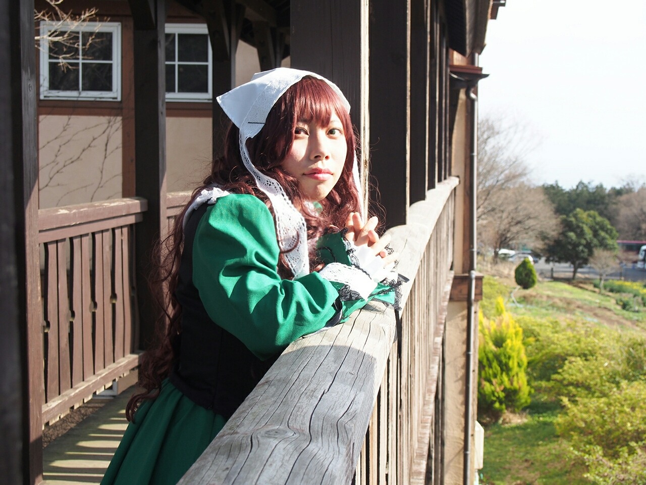 1girl braid brown_hair building dress green_dress hood long_hair solo suiseiseki twin_braids