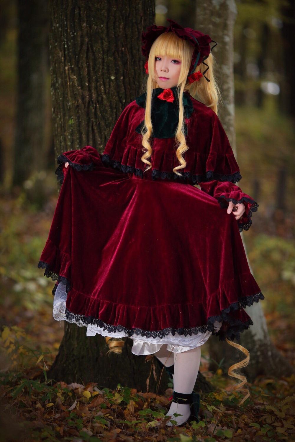 1girl blonde_hair blue_eyes blurry blurry_background bonnet bow dress flower long_hair long_sleeves photo red_dress shinku solo standing
