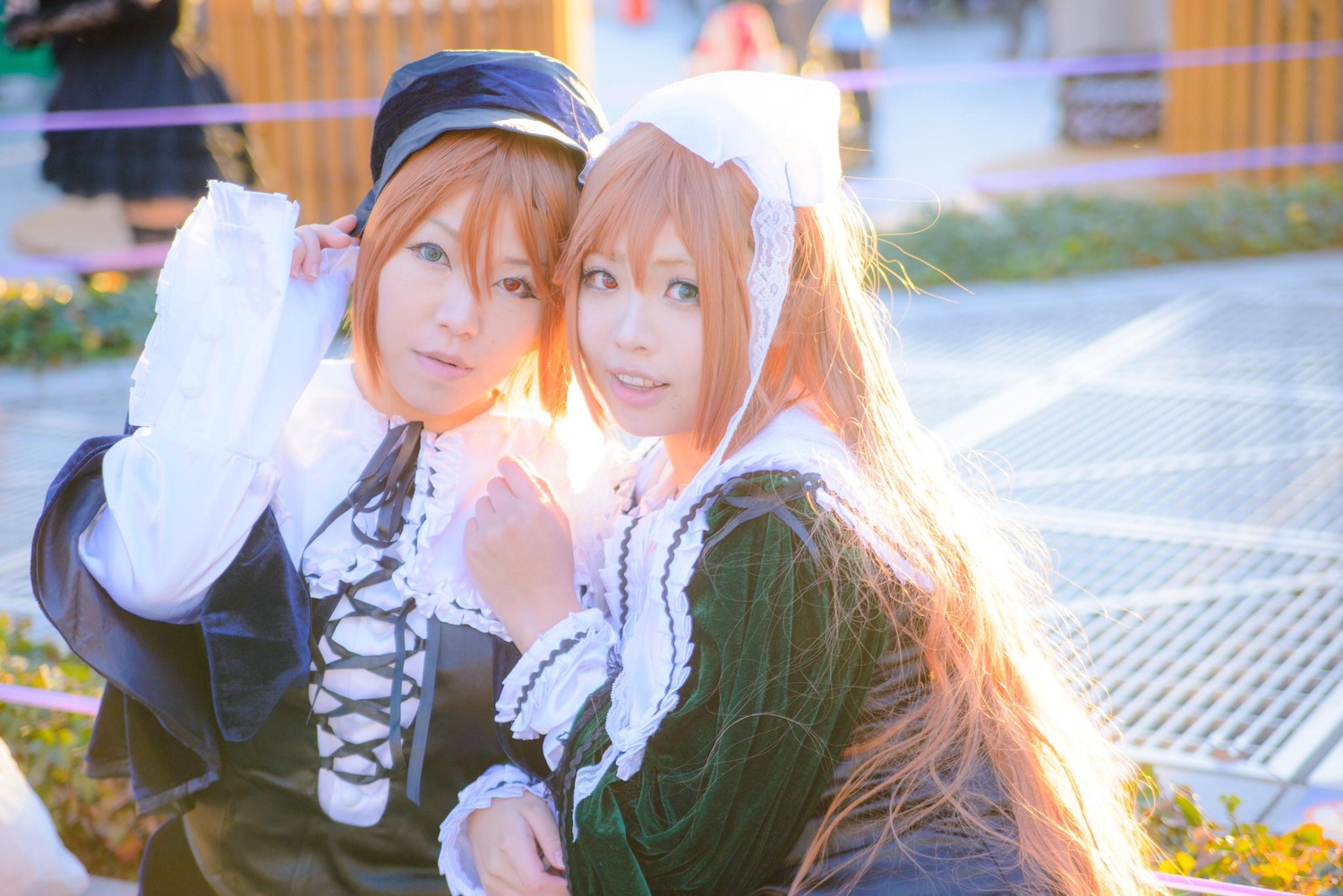 2girls blonde_hair blue_eyes blurry building city depth_of_field dress frills green_dress hat heterochromia long_hair long_sleeves multiple_cosplay multiple_girls outdoors red_eyes ribbon sisters smile suiseiseki tagme twins