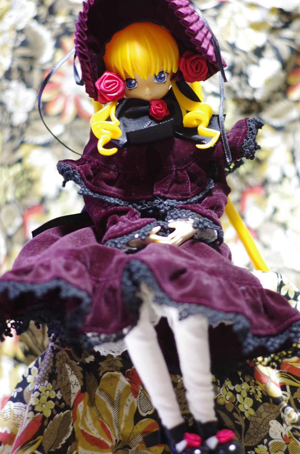 1girl blonde_hair blue_eyes blurry blurry_background blurry_foreground bonnet depth_of_field doll dress flower frills long_hair motion_blur photo pink_flower pink_rose red_flower rose shinku solo