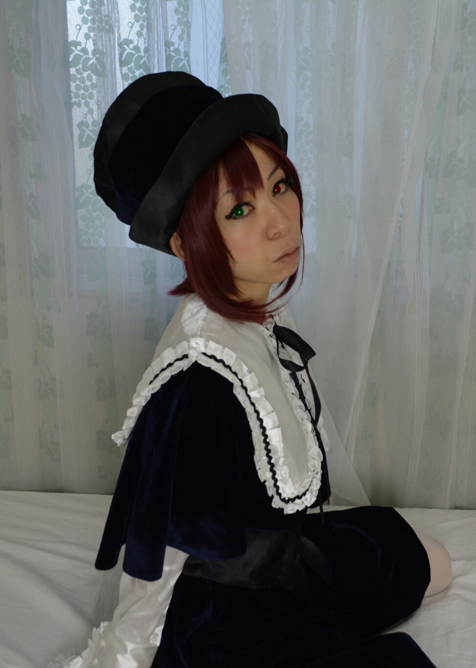 1girl black_dress brown_hair closed_mouth curtains dress green_eyes hat heterochromia lips long_sleeves looking_at_viewer red_eyes short_hair sitting solo souseiseki