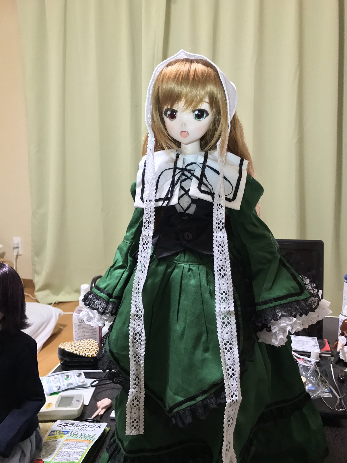 1girl brown_hair curtains doll dress green_dress green_eyes heterochromia long_hair long_sleeves open_mouth ribbon solo standing suiseiseki