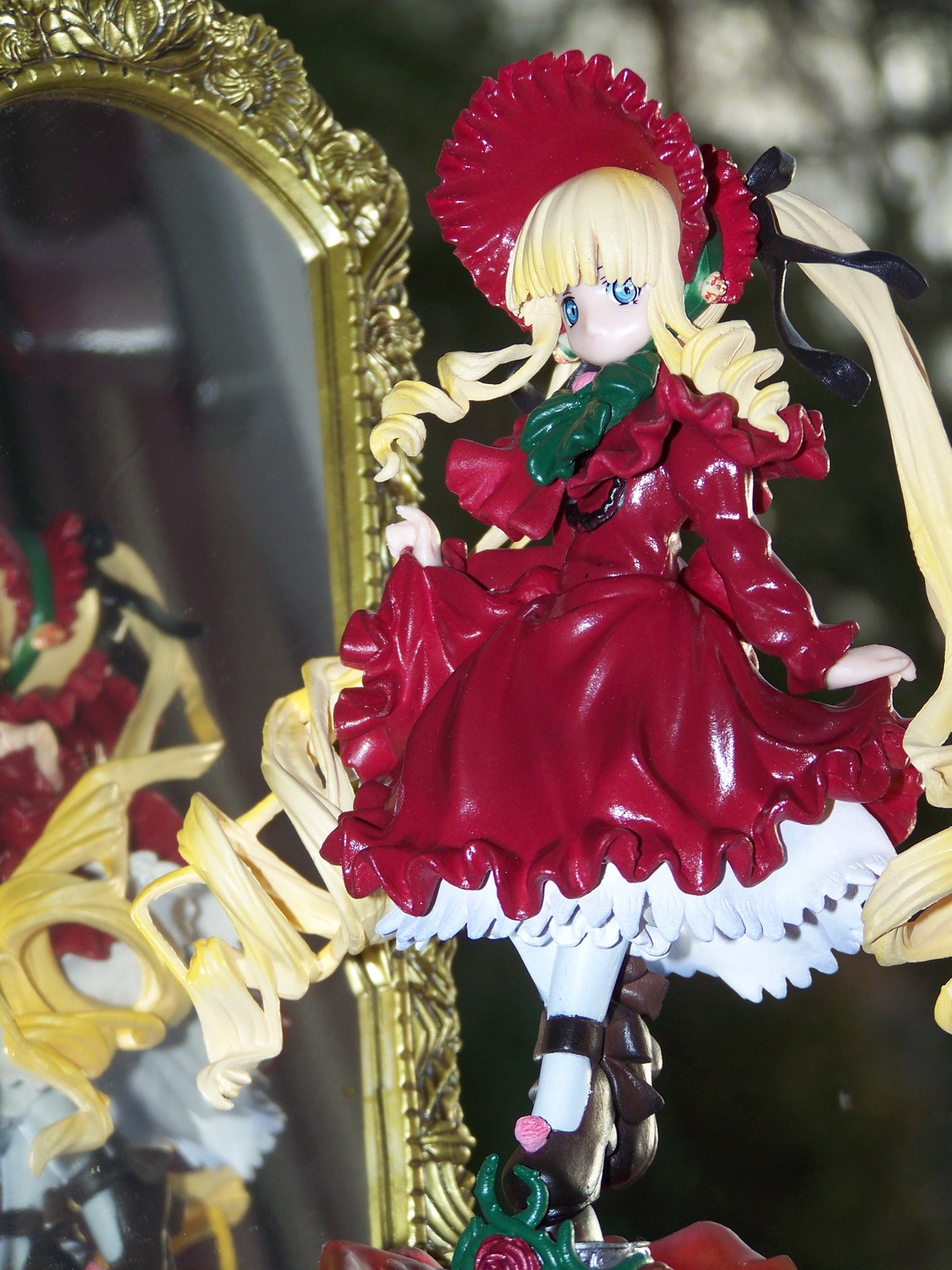 1girl blonde_hair blue_eyes blurry bonnet bow depth_of_field doll dress drill_hair flower frills full_body long_hair long_sleeves looking_at_viewer pink_flower pink_rose red_dress red_flower red_rose rose shinku solo standing twin_drills