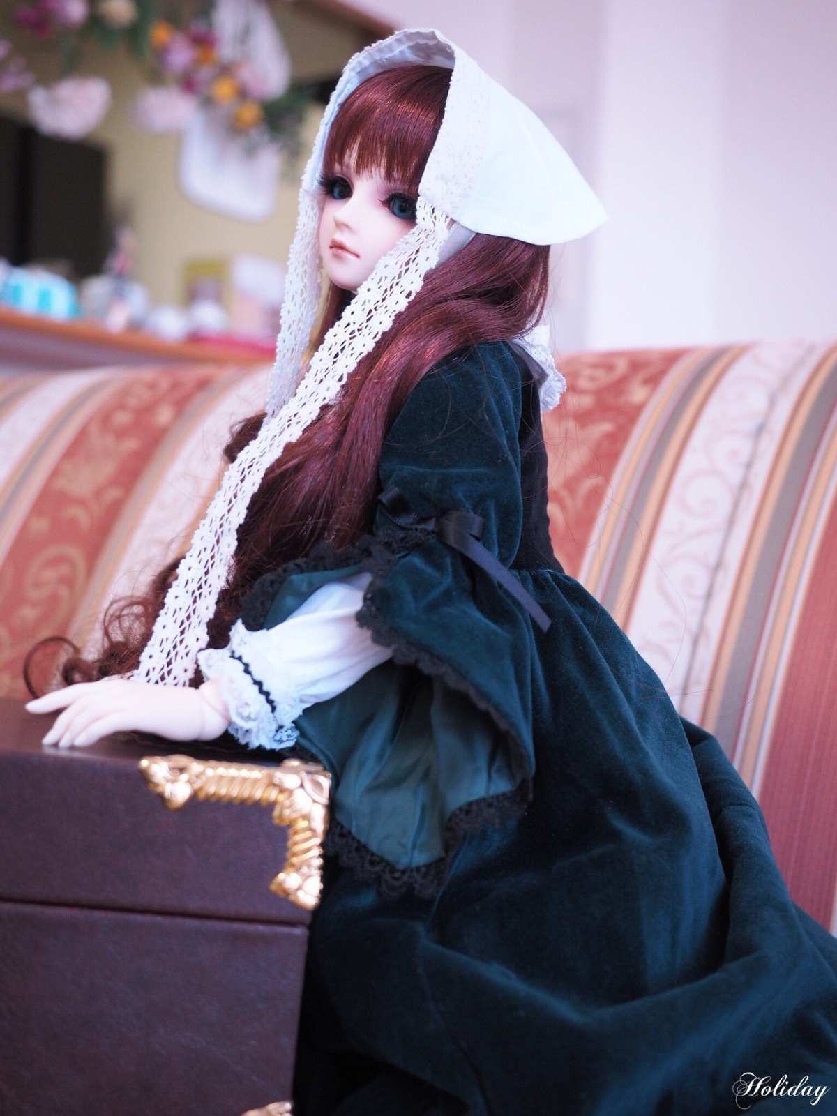 1girl artist_name bangs blue_dress blue_eyes blurry blurry_background blurry_foreground brown_hair closed_mouth depth_of_field doll dress hood indoors lace long_hair long_sleeves looking_at_viewer photo signature solo standing suiseiseki veil