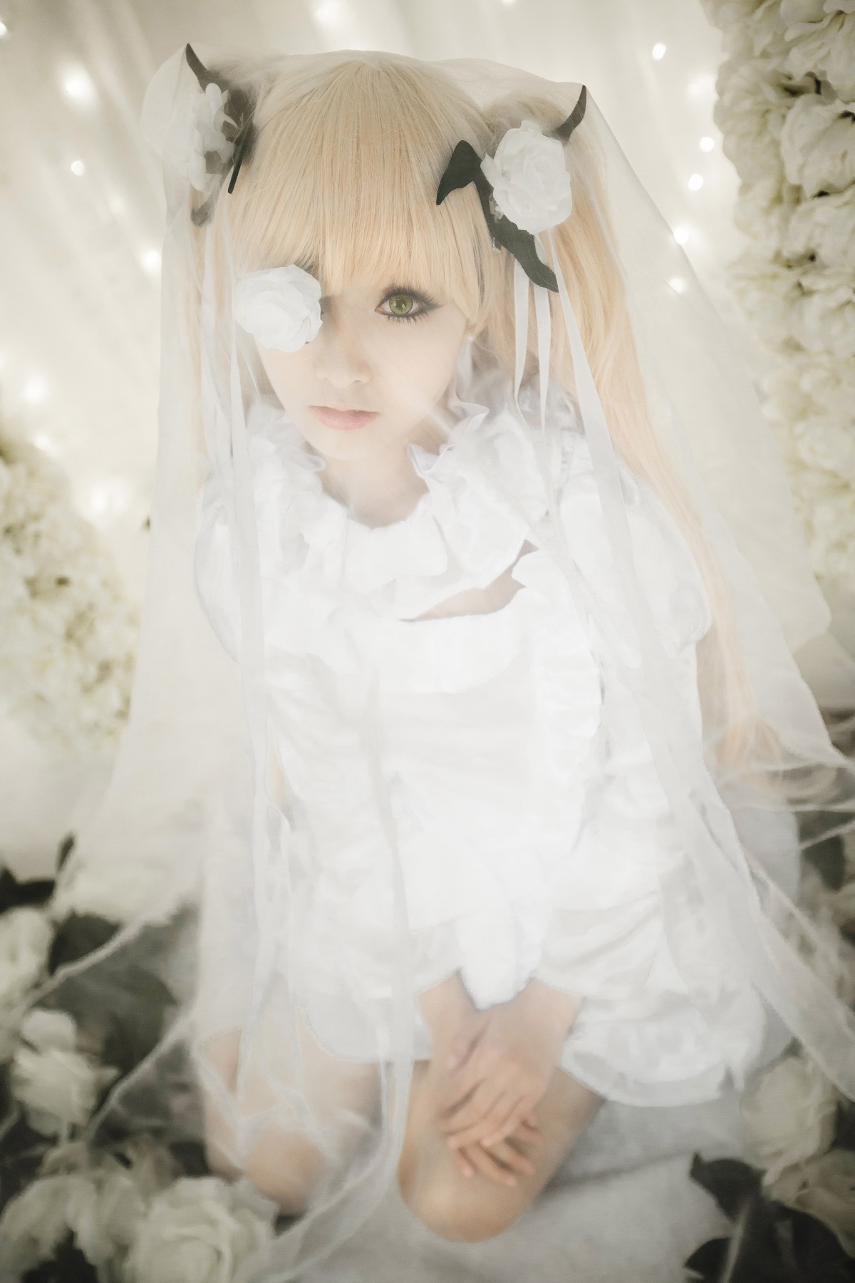 1girl bandages bangs blonde_hair blurry blurry_foreground depth_of_field eyepatch flower hair_flower hair_ornament kirakishou lips long_hair looking_at_viewer sitting solo white_flower white_sweater